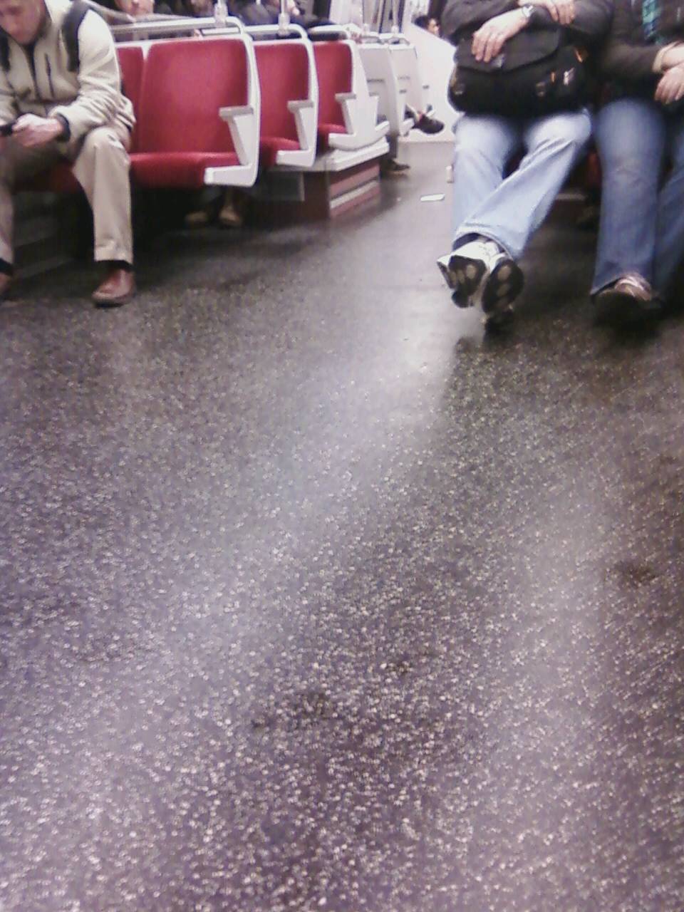 Modified WMATA/DC Metro 6000
series car interior. Note the carpet on the floor has been removed, making
for a significantly noisier and less esthetic ride, a forerunner of the
7000 series railcar. Also note the ugly, overpowering, industrial
cool-white fluorescent (or LED) lighting. For further details, please
visit www.wirelessnotes.org.